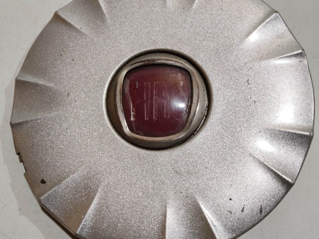201298 Fiat Idea alufelni közép kupak, a képen látható sérüléssel, 2 rögzítőfűl törött