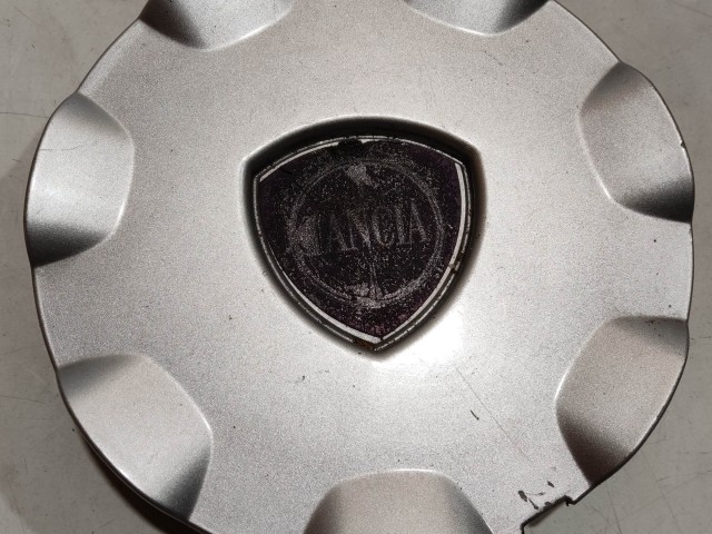 204299 Lancia Delta 2008-2014 Felni közép kupak, a képen látható sérüléssel
