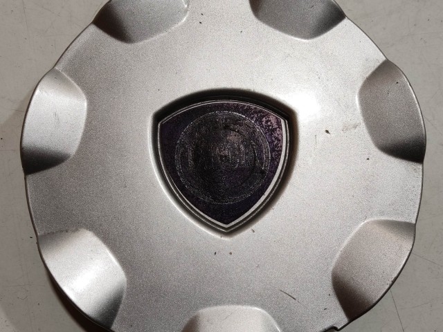 204300 Lancia Delta 2008-2014 Felni közép kupak, a képen látható sérüléssel