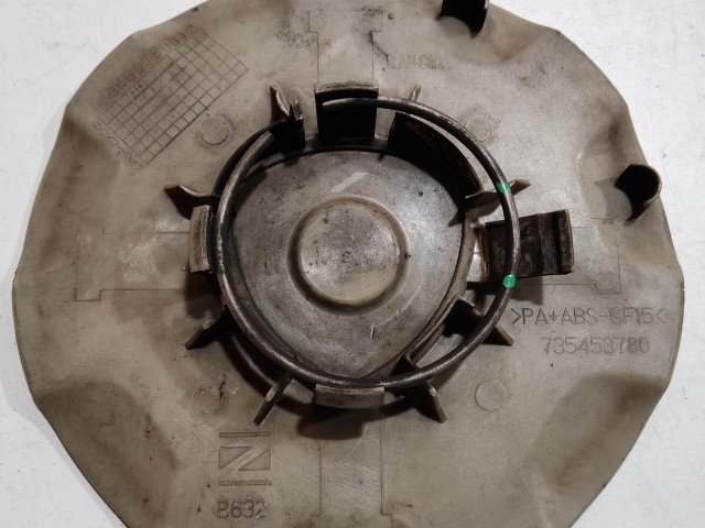 204300 Lancia Delta 2008-2014 Felni közép kupak, a képen látható sérüléssel