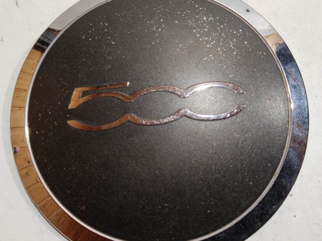 204489 Fiat 500 2007- felni közép kupak, a képen látható állapotban, kettő rögzítő fül törött, rögzítő rugó nélkül!!