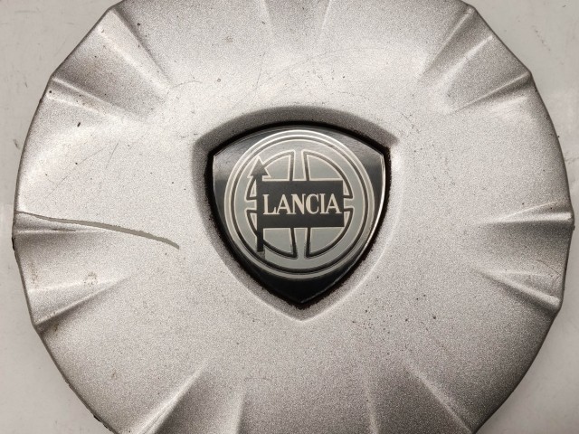 214298 Lancia Ypsilon II. 2003-2011 felni közép kupak, a képen látható állapotban, egy rögzítő fül törött, hiányzik