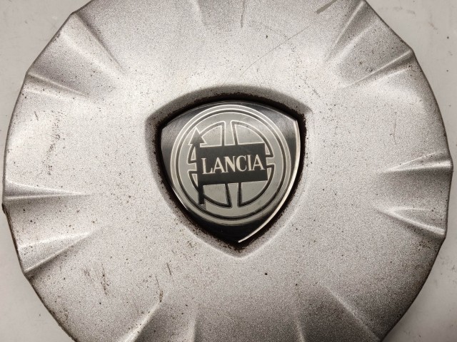 214299 Lancia Ypsilon II. 2003-2011 felni közép kupak, a képen látható állapotban, egy rögzítő fül törött, hiányzik