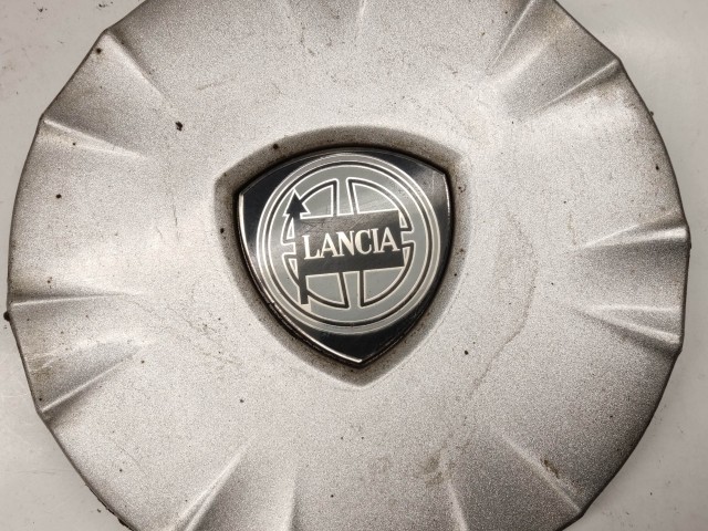 214301 Lancia Ypsilon II. 2003-2011 felni közép kupak, a képen látható állapotban, egy rögzítő fül törött, hiányzik