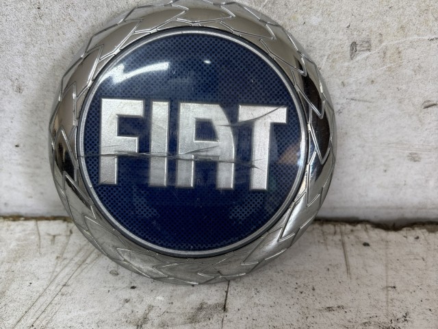 213603 Fiat Grande Punto, Stilo, Croma, Multipla, Doblo II. kék színű első embléma 98 mm átmérő, a képen látható sérüléssel